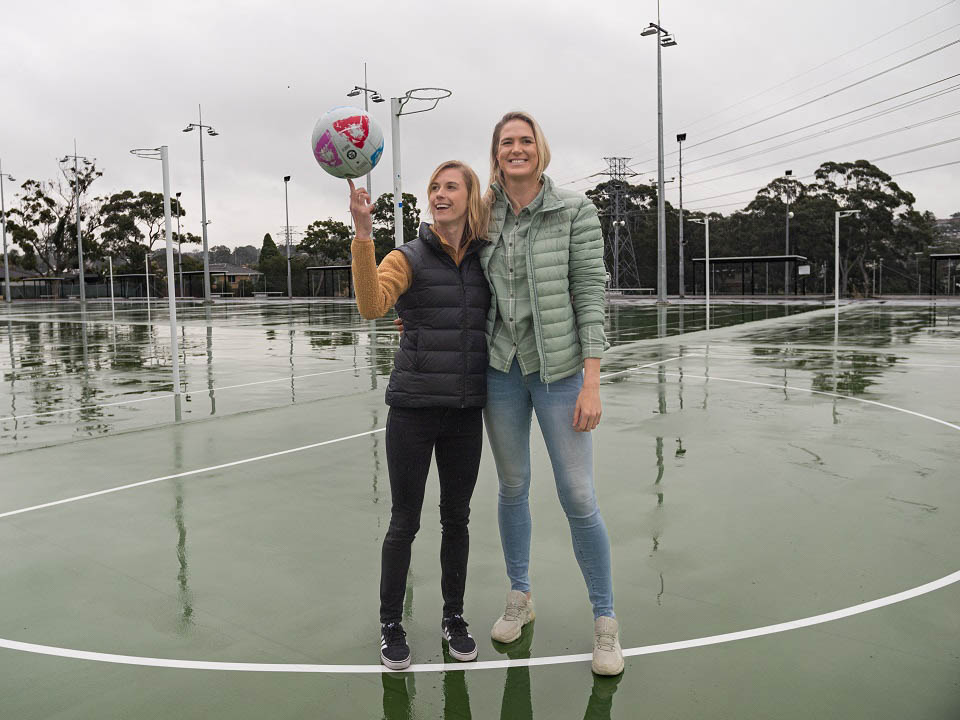 Kate standing on a court with netballer Caitlin Bassett Kate standing on a court with netballer Caitlin Bassett