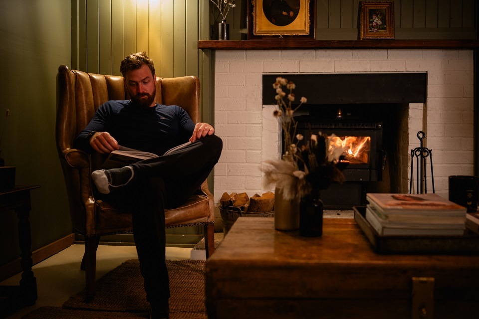 Man reading by a fireplace Man reading by a fireplace