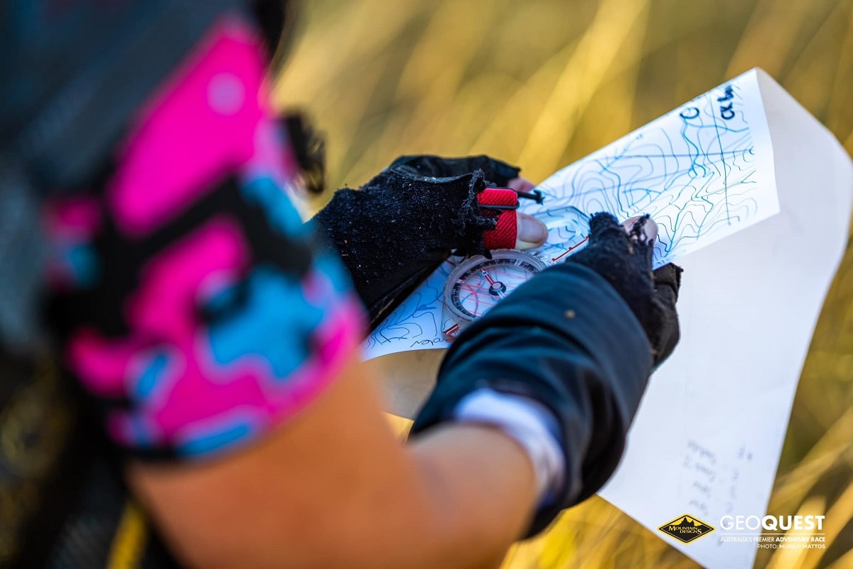 Kim sets a bearing using a paper map and compass.