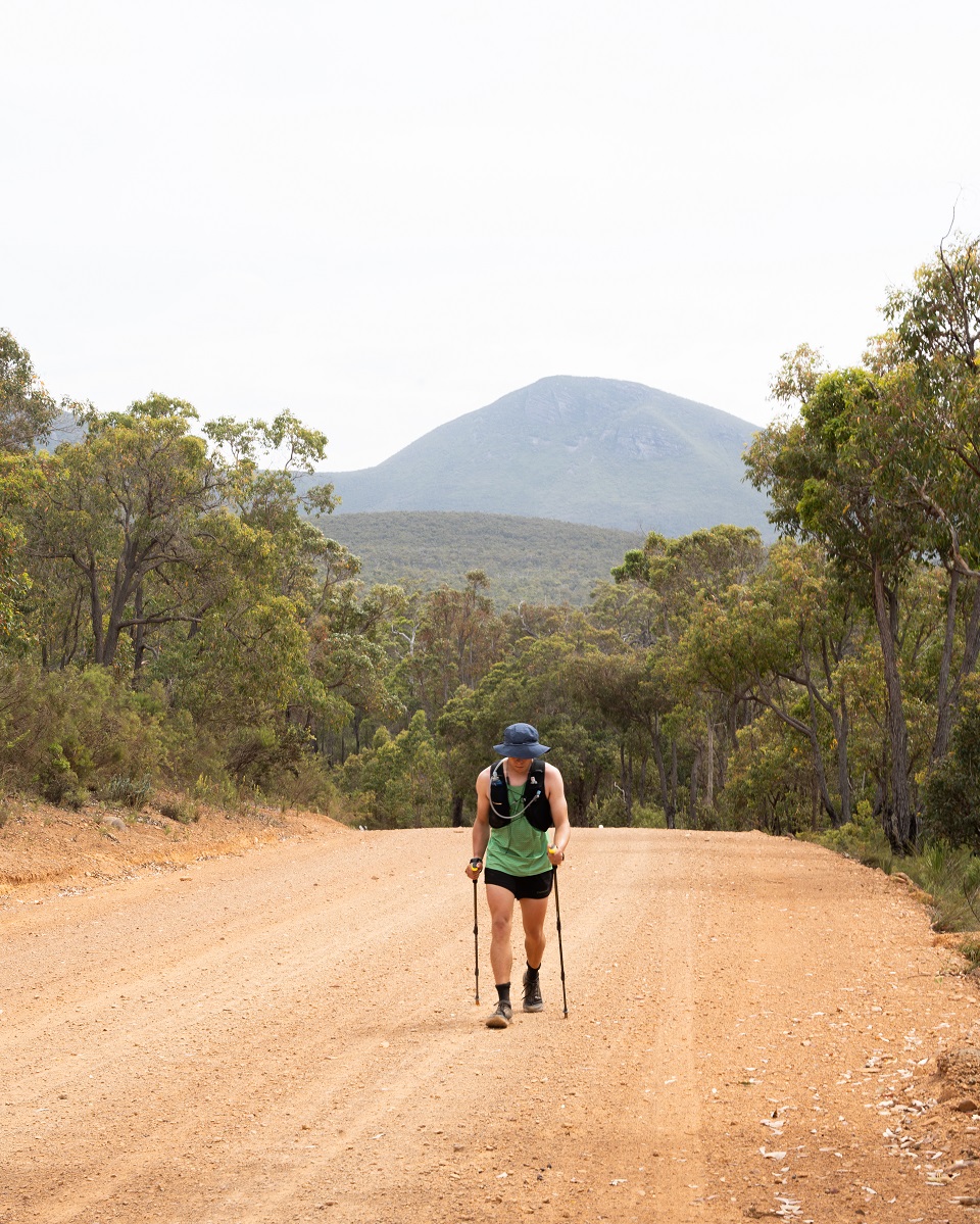 Jake walking on a road with Tread Carbon Trekking Poles Jake walking on a road with Tread Carbon Trekking Poles