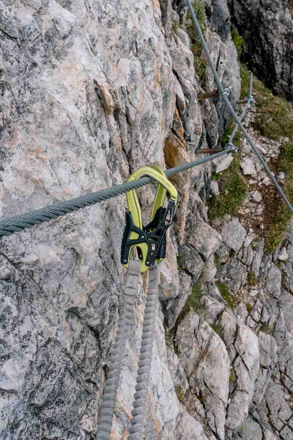 Close up of clipping Via Ferrata set carabiners onto the wire Close up of clipping Via Ferrata set carabiners onto the wire